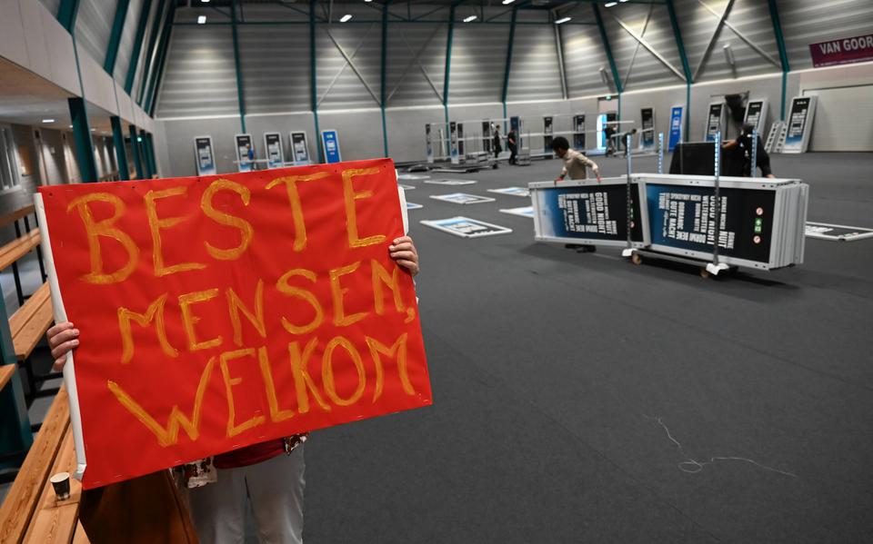 Drukke bedoening in- en rond sporthal De Slenken in de Wijk voor nachtopvang vluchtelingen
